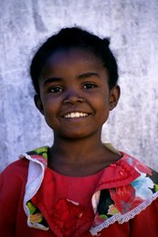 Child;-Comoros-Archipelago;-France;-Indian-Ocean;-Kaleidos;-Kaleidos-images;-La-parole-à-limage;-Laurent-Abad;-Little-girl;-Mayotte;-Portrait;-Red-dress;-Smile;-Stories-Pictures